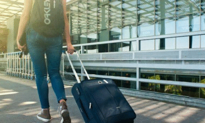 a woman with a suitcase, thinking about how moving internationally changes the way you think about the US